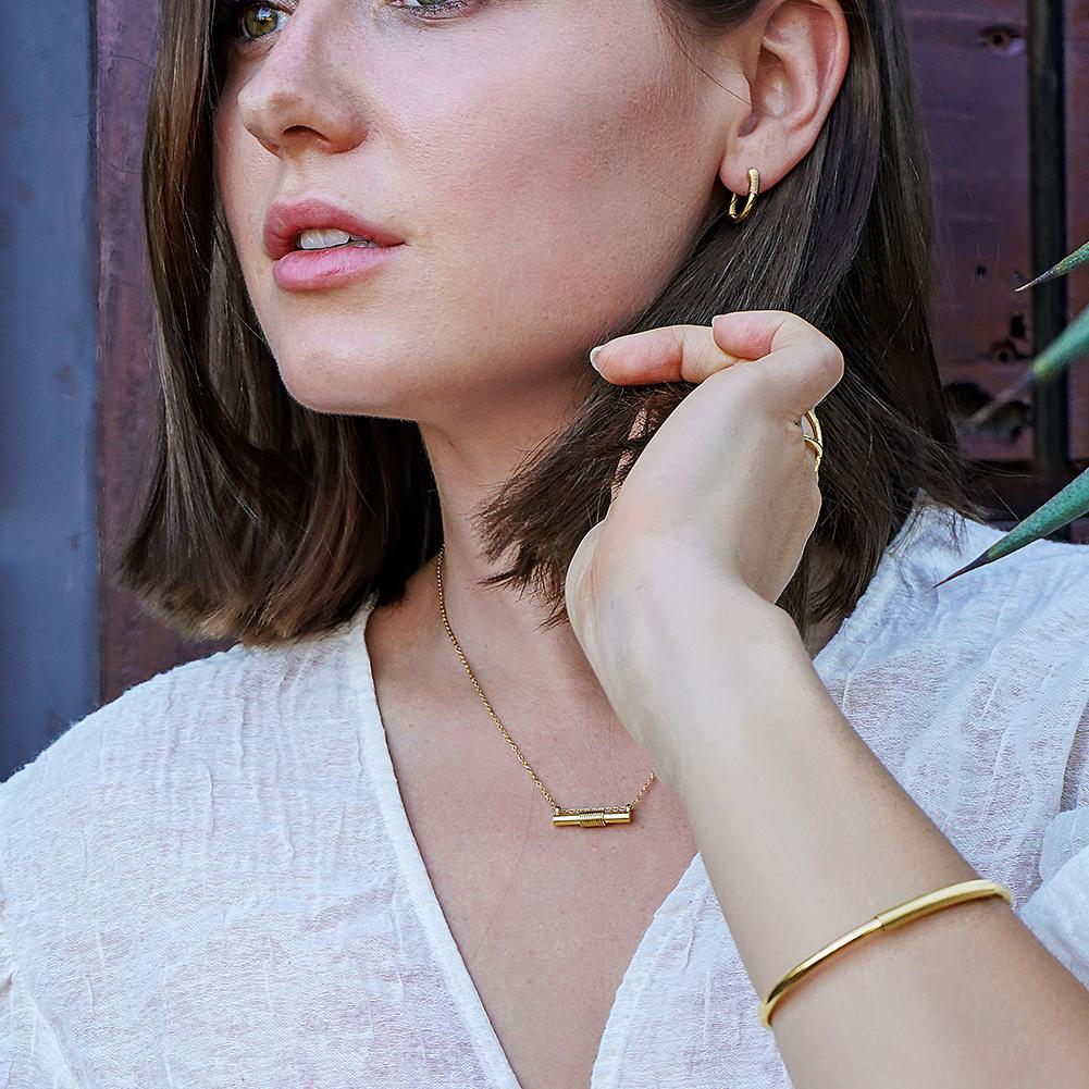 Wire Set featuring a mini bar necklace, tiny hoop earrings, and a cuff bangle in 14k gold over stainless steel, elegantly displayed in a gift box.