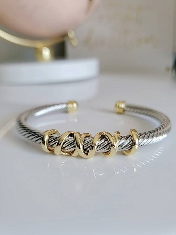 Elegant wrap around design cable bracelet with 18K gold filled accents, showcasing a unique pattern and durable stainless steel material.