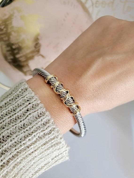 Elegant wrap around design cable bracelet with 18K gold filled accents, showcasing a unique pattern and durable stainless steel material.