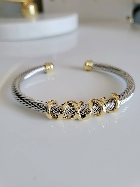 Elegant wrap around design cable bracelet with 18K gold filled accents, showcasing a unique pattern and durable stainless steel material.