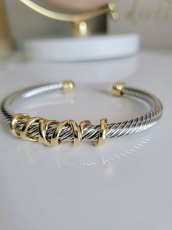 Elegant wrap around design cable bracelet with 18K gold filled accents, showcasing a unique pattern and durable stainless steel material.