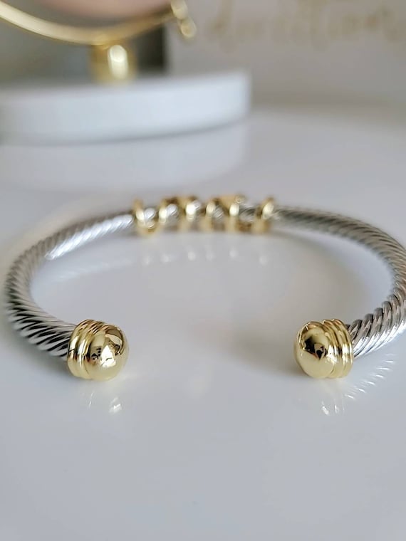 Elegant wrap around design cable bracelet with 18K gold filled accents, showcasing a unique pattern and durable stainless steel material.