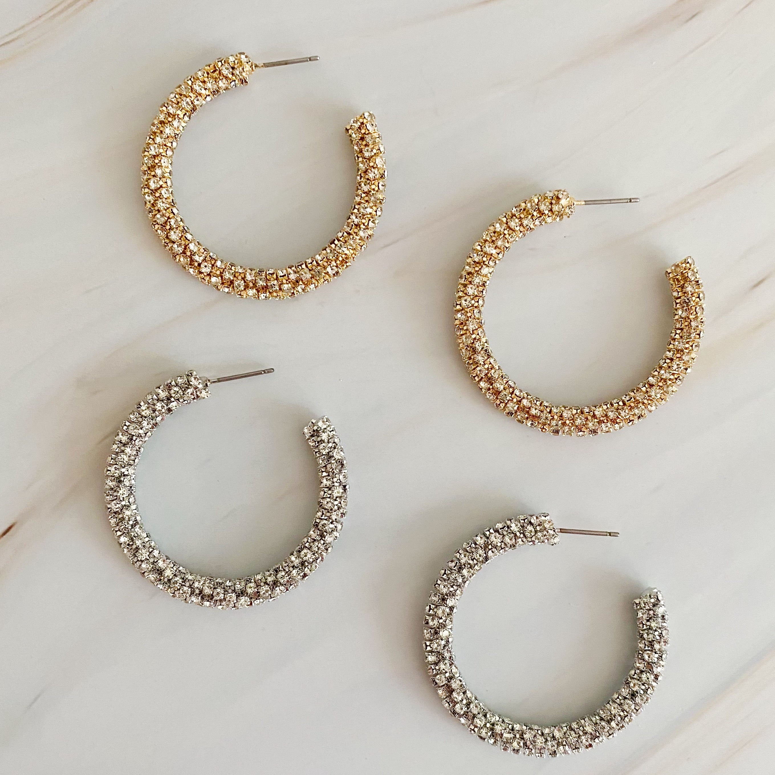 A pair of Wrapped In Shine Hoop Earrings featuring sparkling crystals on a classic hoop design, showcasing elegance and style.