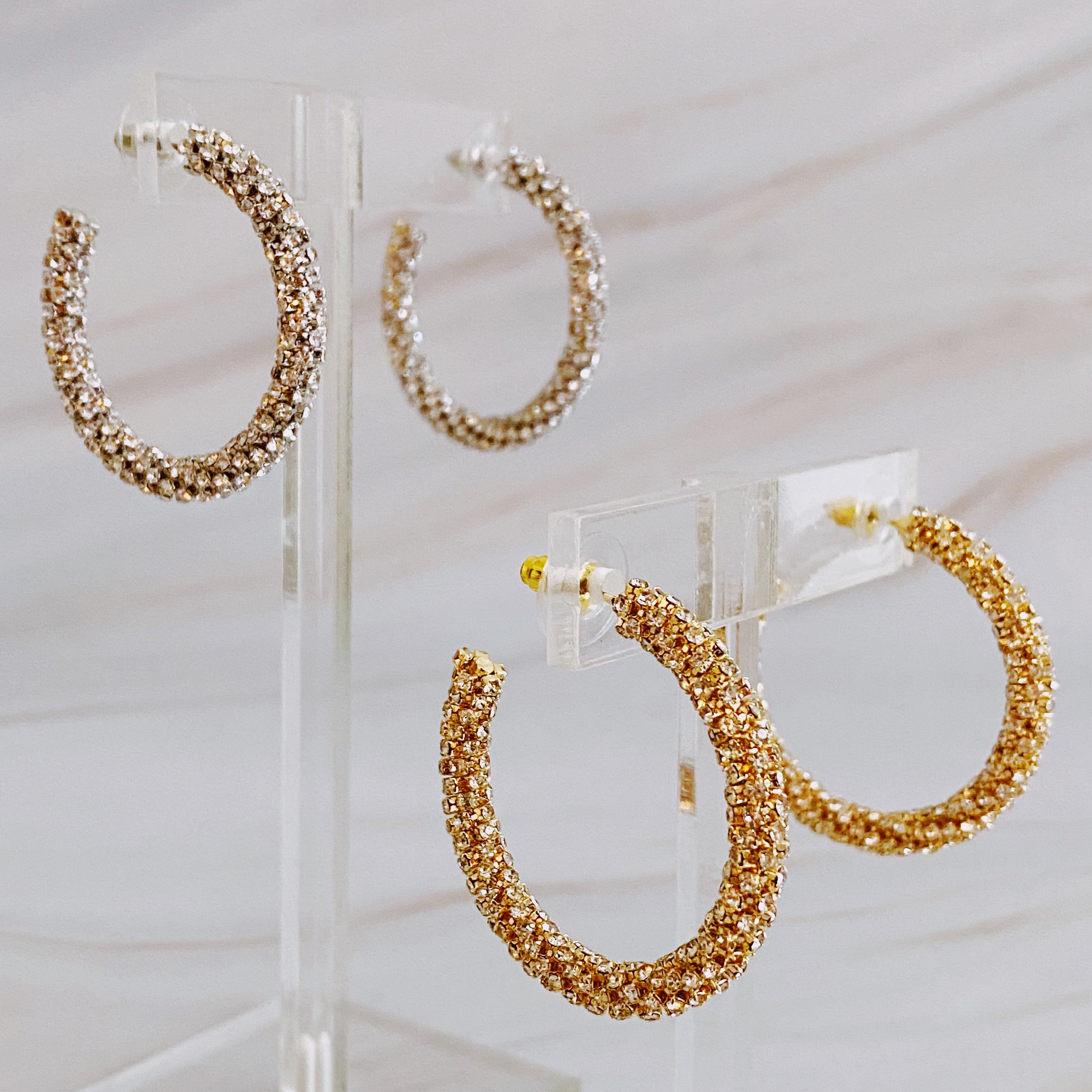 A pair of Wrapped In Shine Hoop Earrings featuring sparkling crystals on a classic hoop design, showcasing elegance and style.