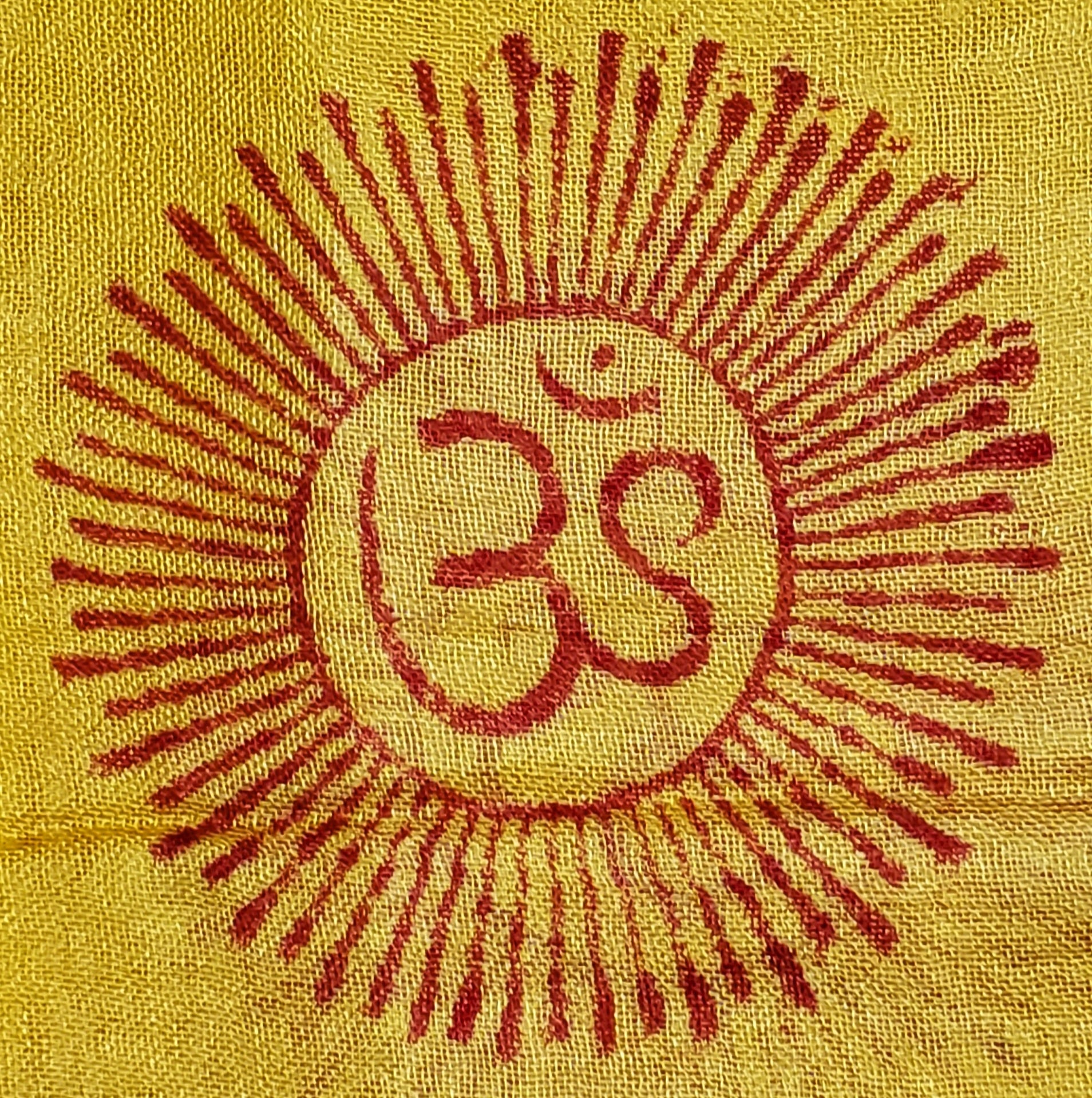 A vibrant yellow scarf featuring spiritual symbols including Om, Ganesha, tridents, and henna patterns, perfect for stylish wear.