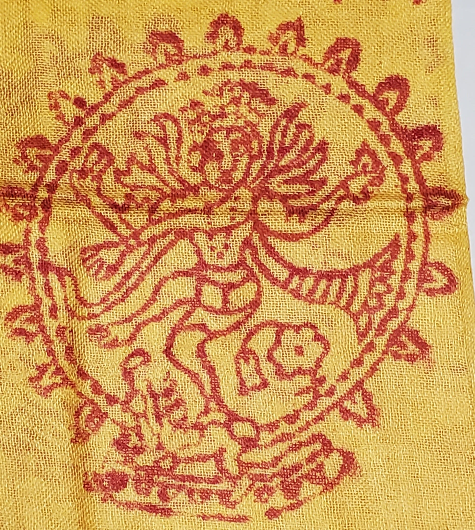 A vibrant yellow scarf featuring spiritual symbols including Om, Ganesha, tridents, and henna patterns, perfect for stylish wear.