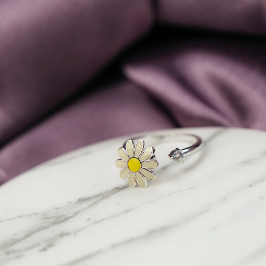 A beautiful yellow rotating sunflower ring with dainty floral design, showcasing its intricate craftsmanship and adjustable fit.