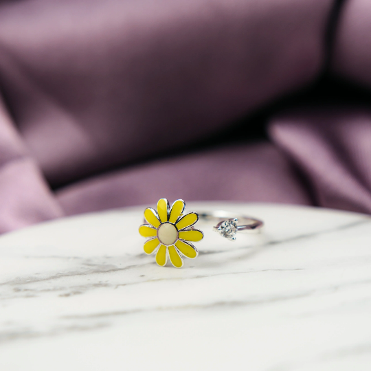 A beautiful yellow rotating sunflower ring with dainty floral design, showcasing its intricate craftsmanship and adjustable fit.