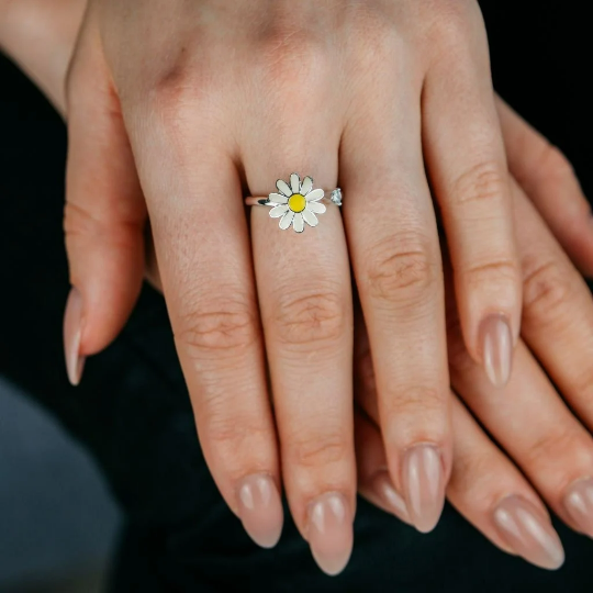 A beautiful yellow rotating sunflower ring with dainty floral design, showcasing its intricate craftsmanship and adjustable fit.