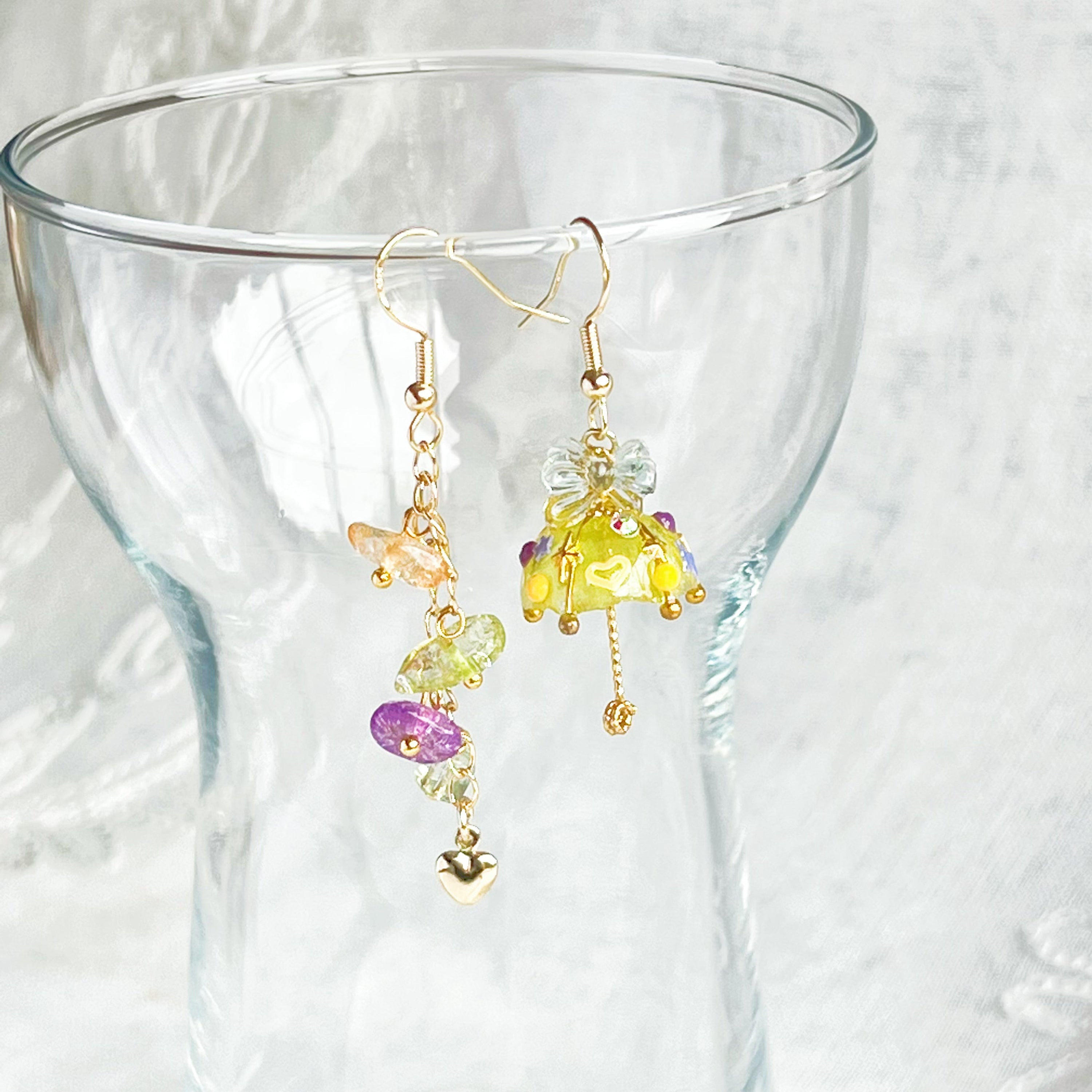 A pair of handmade yellow umbrella drop earrings adorned with colorful rainbow stones, showcasing a unique mismatch design.