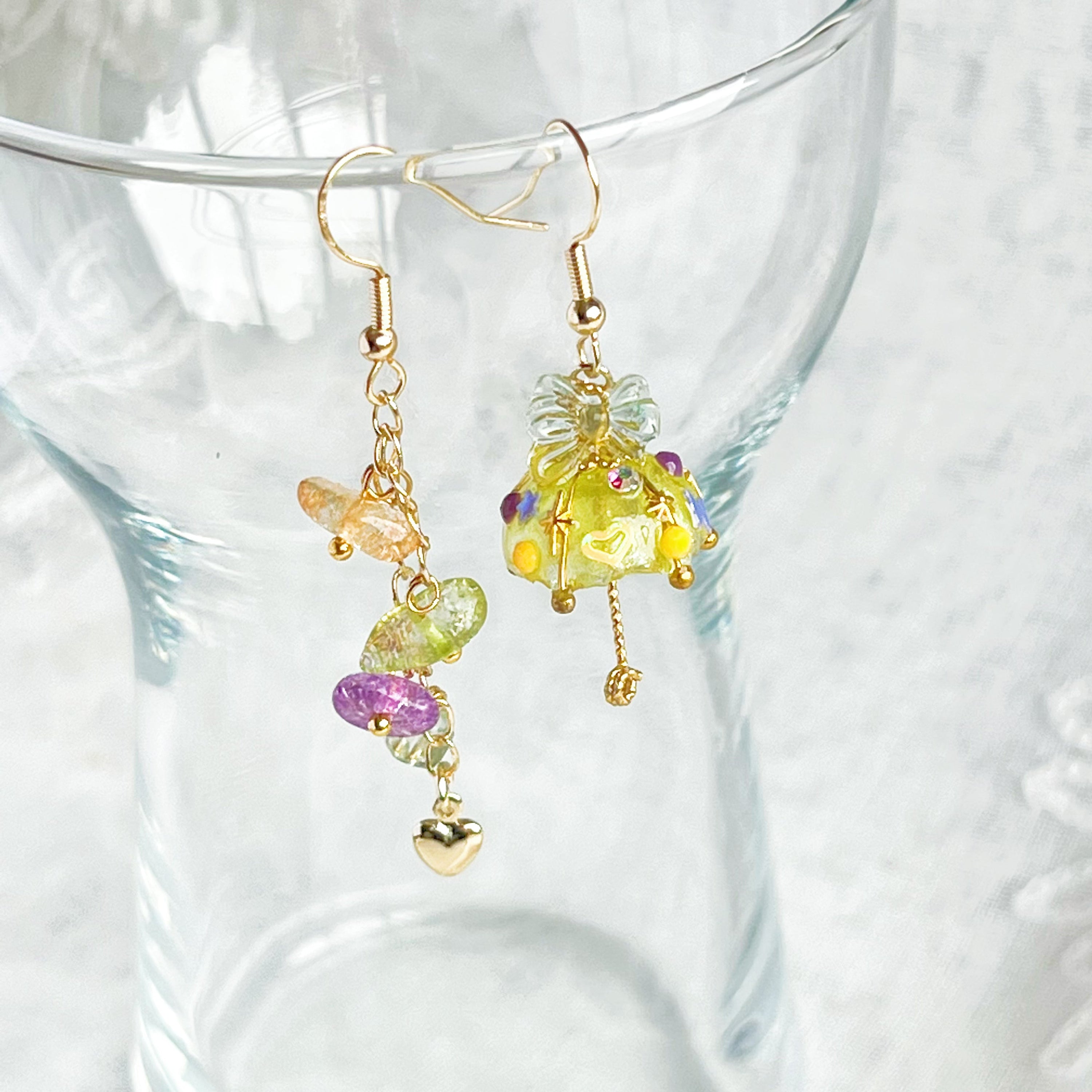 A pair of handmade yellow umbrella drop earrings adorned with colorful rainbow stones, showcasing a unique mismatch design.