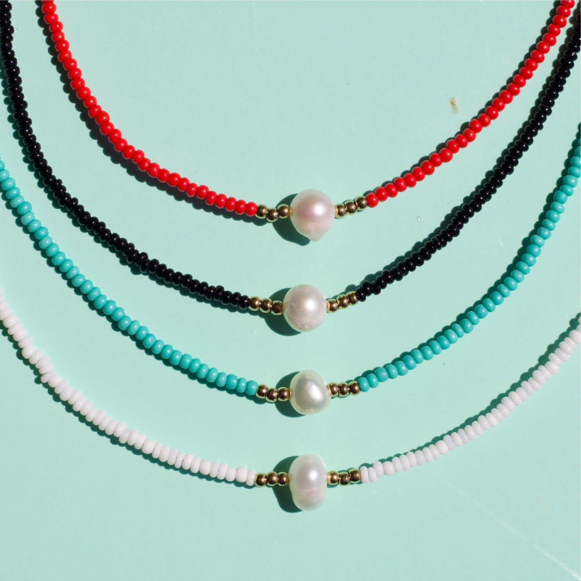 Zagros Beaded Pearl Choker Necklace featuring natural pearls and colored beads on a gold chain.