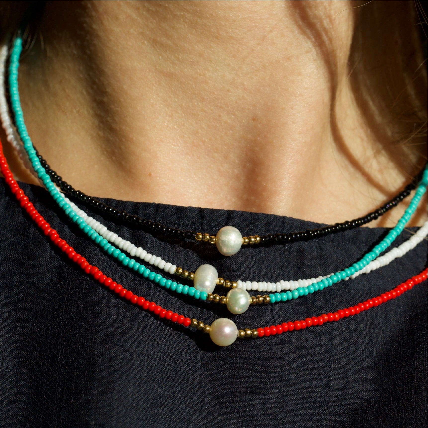 Zagros Beaded Pearl Choker Necklace featuring natural pearls and colored beads on a gold chain.