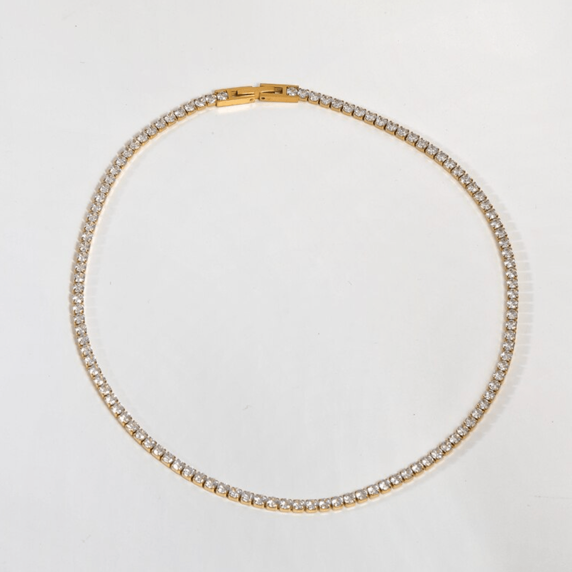 Zebedeo Crystal Choker Necklace featuring clear crystals and 18K gold plating on a stainless steel chain, elegantly displayed.