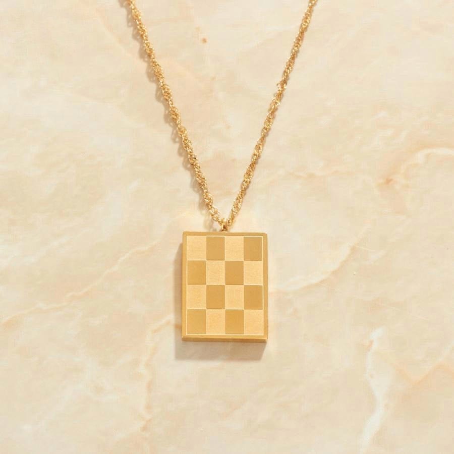 Zeno Checkerboard Gold Pendant Necklace featuring an 18K gold paved pendant and twist rope chain, elegantly displayed on a neutral background.