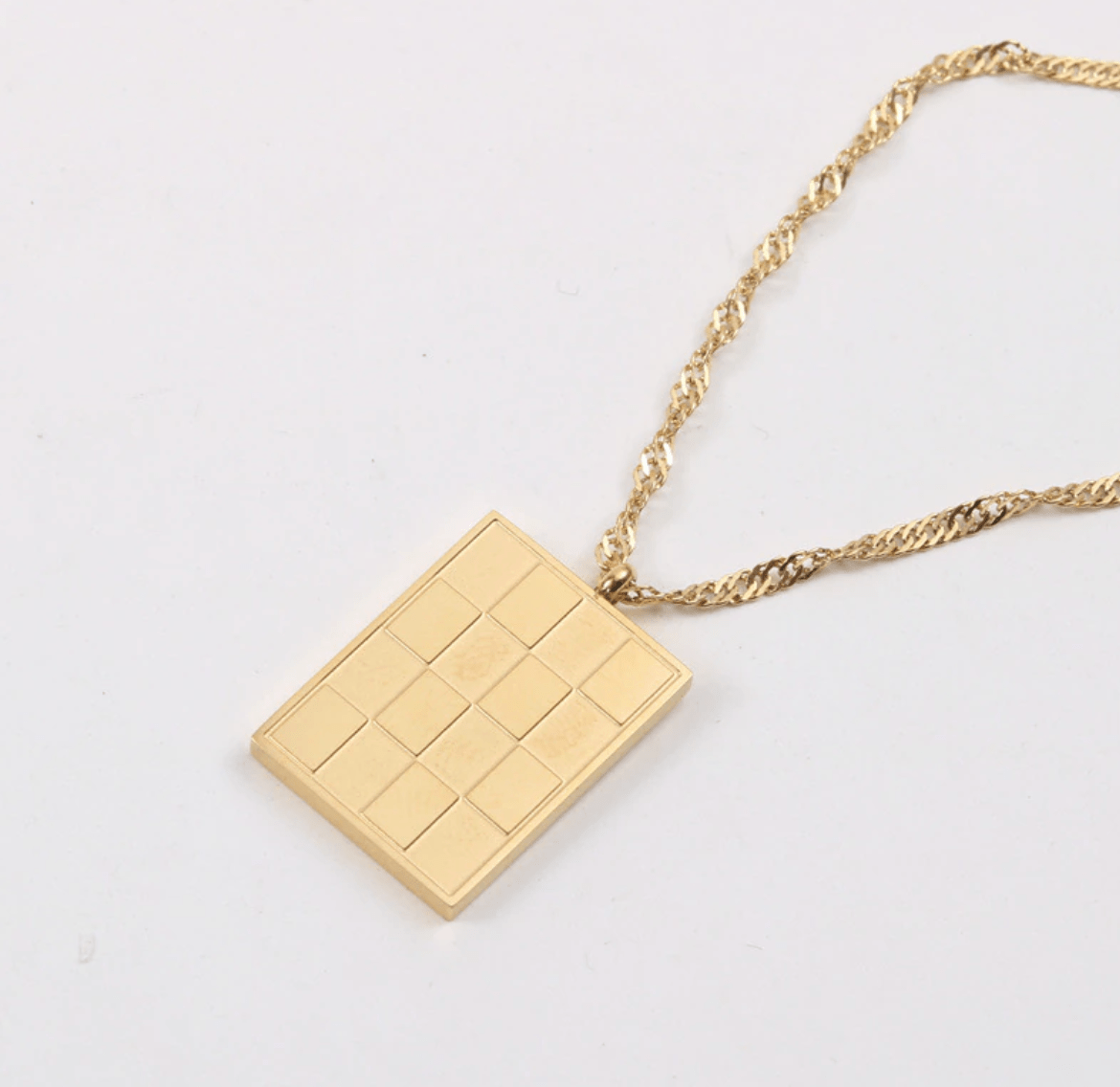 Zeno Checkerboard Gold Pendant Necklace featuring an 18K gold paved pendant and twist rope chain, elegantly displayed on a neutral background.