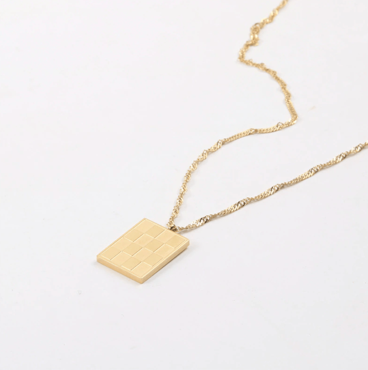 Zeno Checkerboard Gold Pendant Necklace featuring an 18K gold paved pendant and twist rope chain, elegantly displayed on a neutral background.