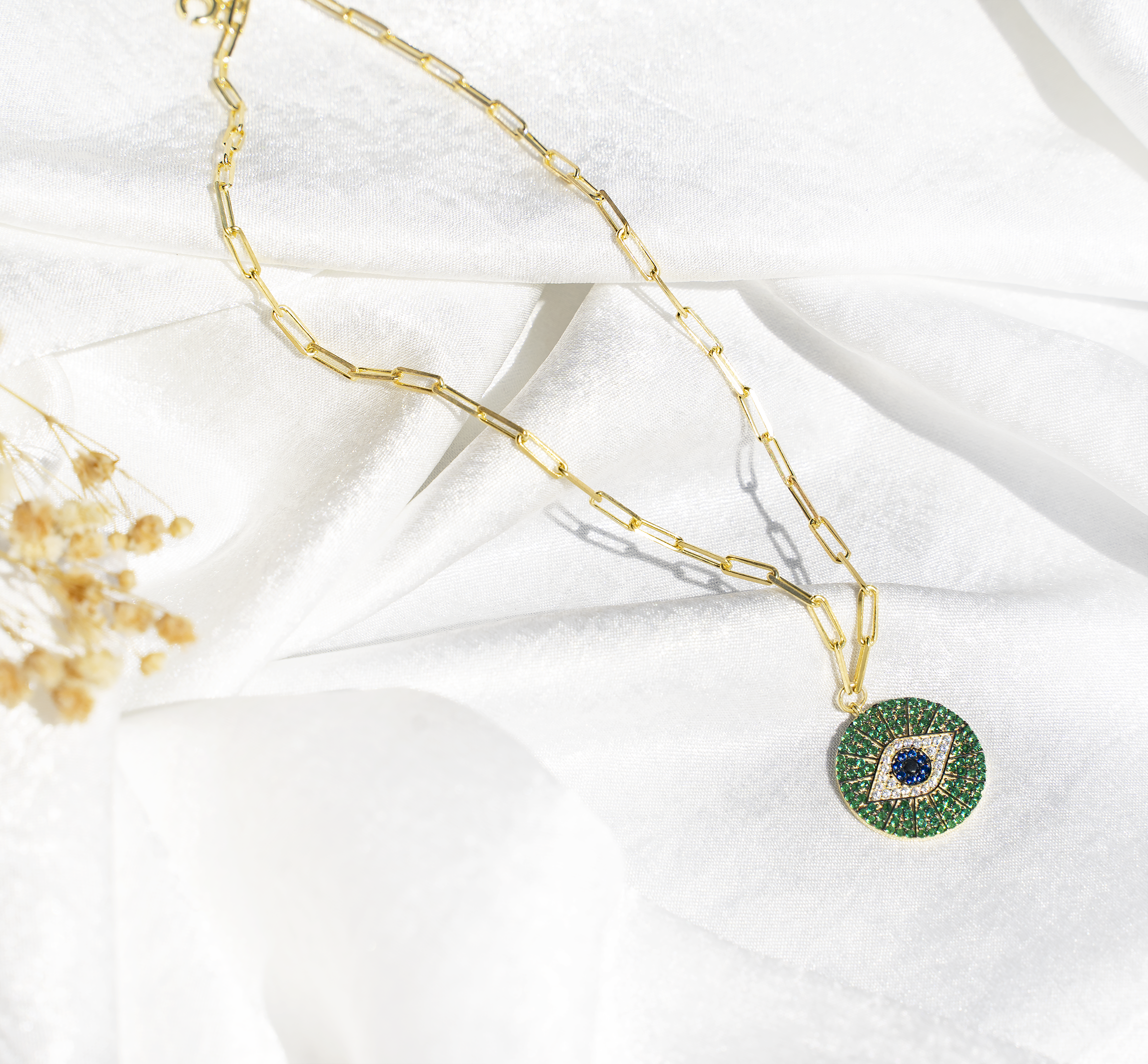 ZIBA Necklace featuring a medallion evil eye pendant with emerald green, royal blue, and bright white cubic zirconias on a 925 sterling silver chain.