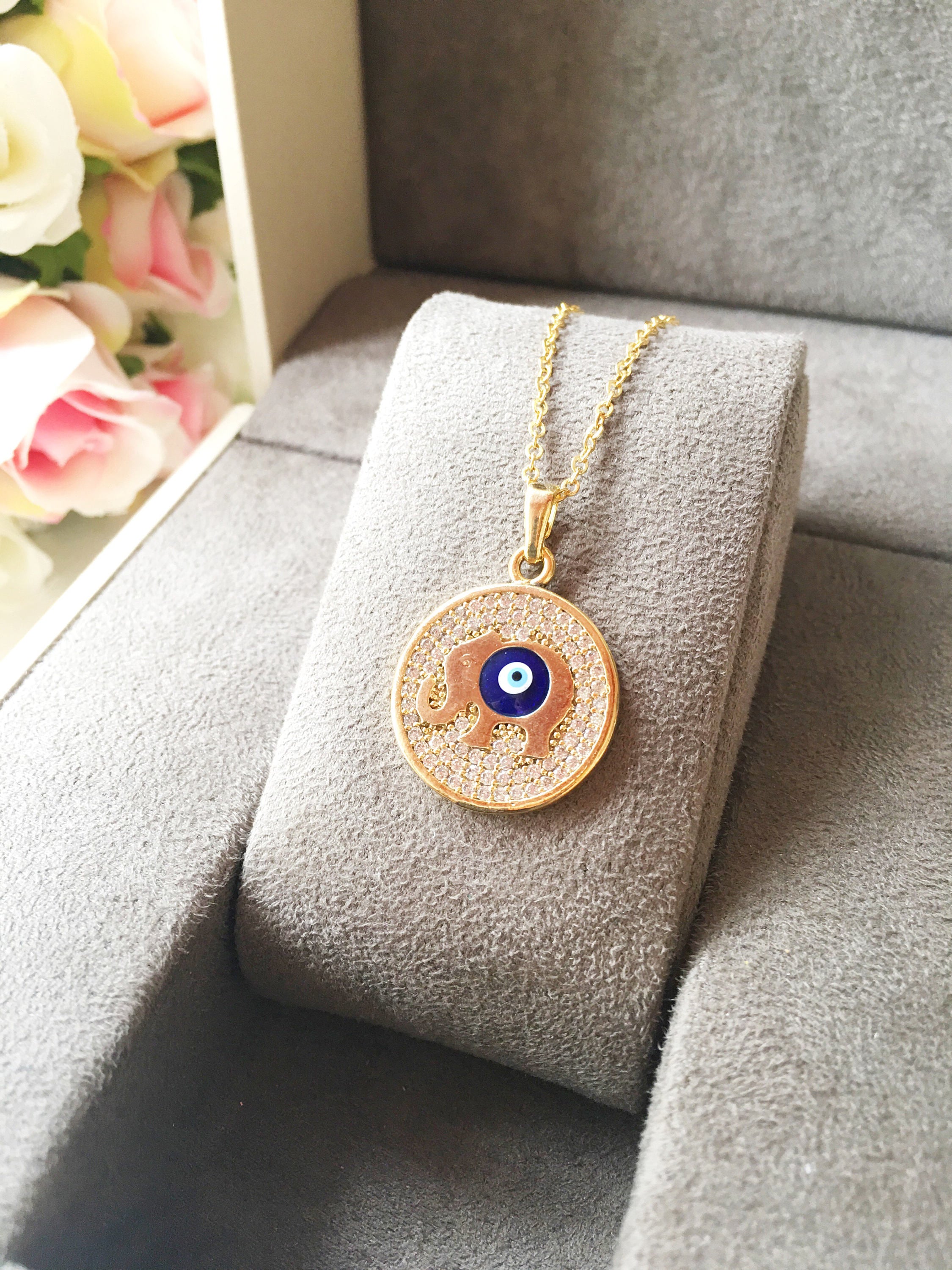 Zircon Evil Eye Necklace featuring an elephant charm on a rose gold chain, symbolizing protection and good luck.