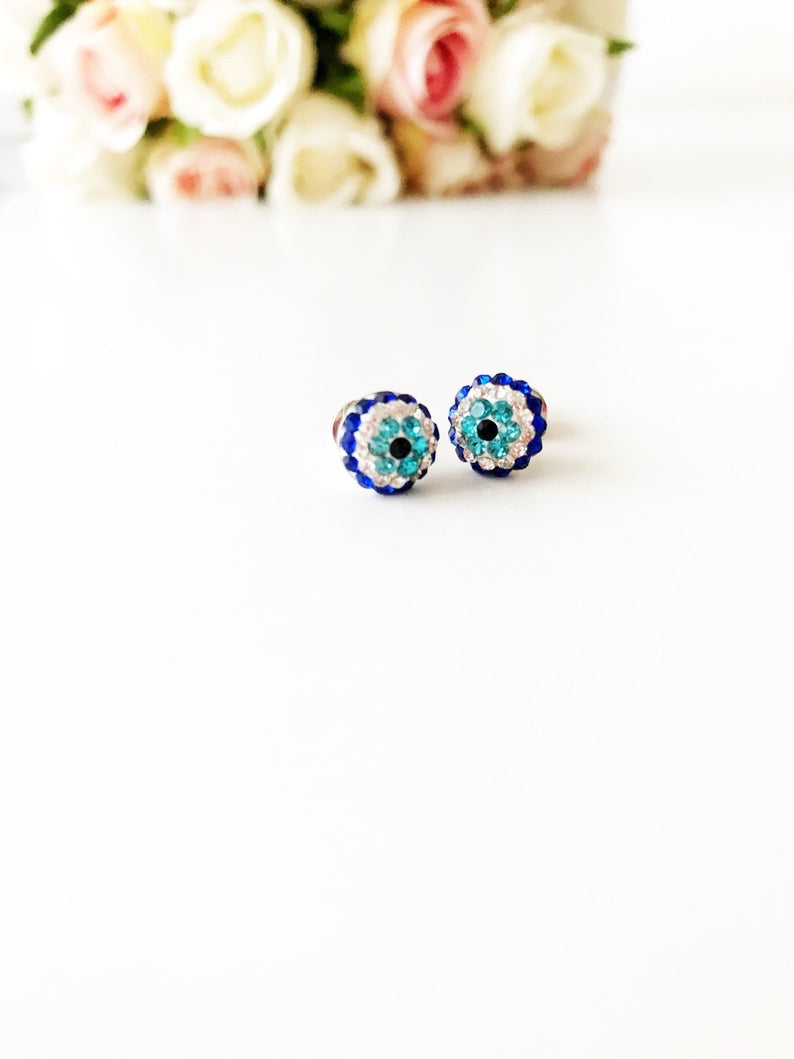 A pair of handmade silver zirconia evil eye earrings, featuring a minimalist design with a protective symbol.