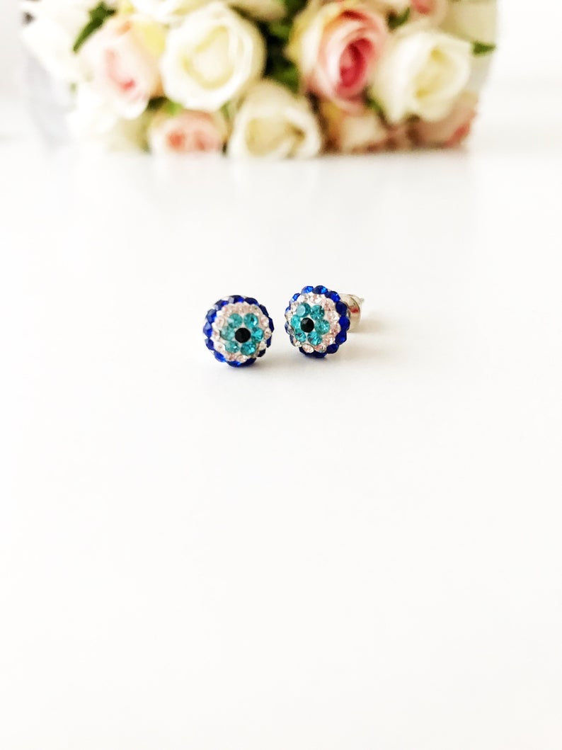 A pair of handmade silver zirconia evil eye earrings, featuring a minimalist design with a protective symbol.