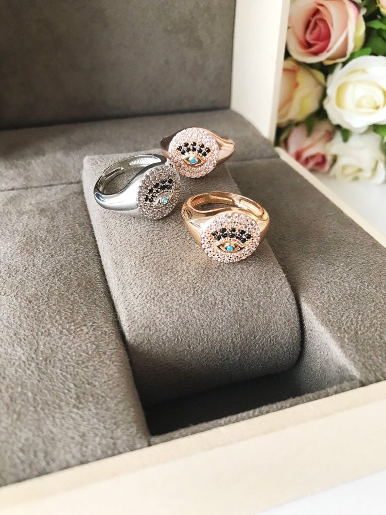 A beautiful adjustable Zirconia Evil Eye Ring featuring sparkling zirconia beads in a gold and silver finish, symbolizing protection and elegance.