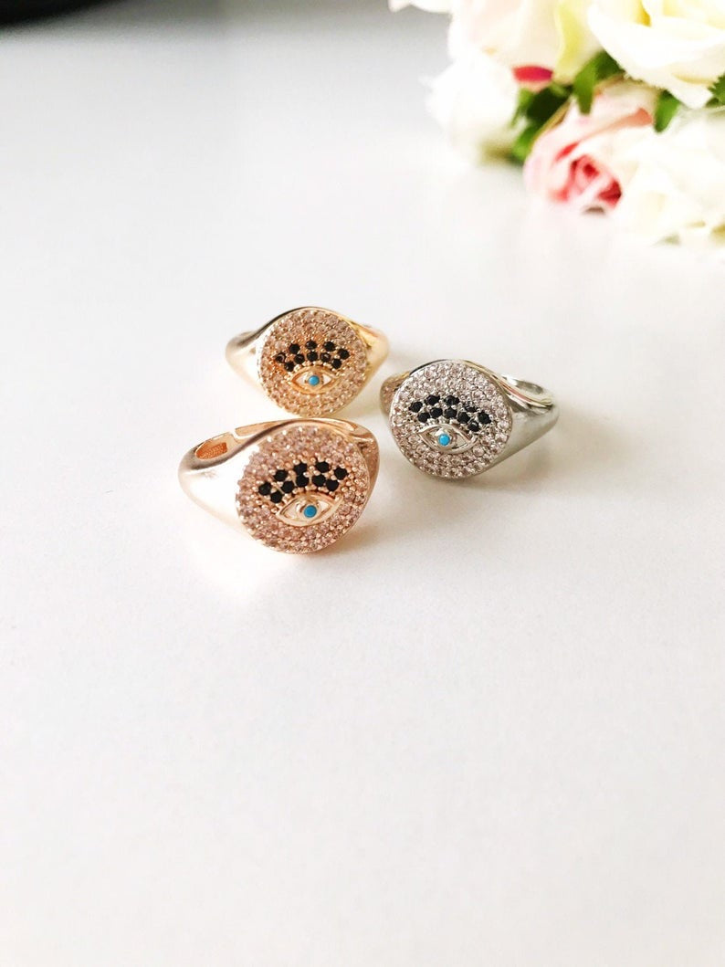 A beautiful adjustable Zirconia Evil Eye Ring featuring sparkling zirconia beads in a gold and silver finish, symbolizing protection and elegance.