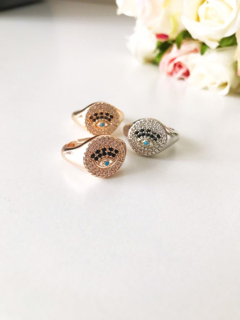 A beautiful adjustable Zirconia Evil Eye Ring featuring sparkling zirconia beads in a gold and silver finish, symbolizing protection and elegance.