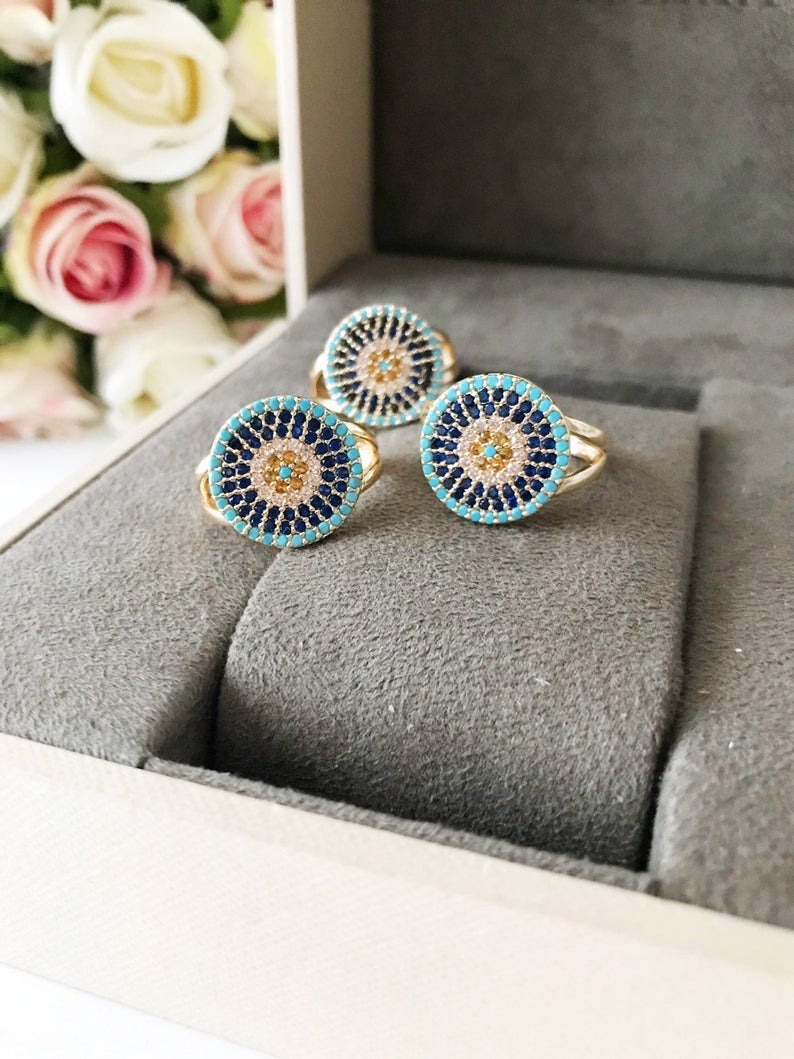 A beautiful adjustable Zirconia Evil Eye Ring featuring a blue evil eye design, adorned with sparkling zirconia beads, perfect for protection and style.