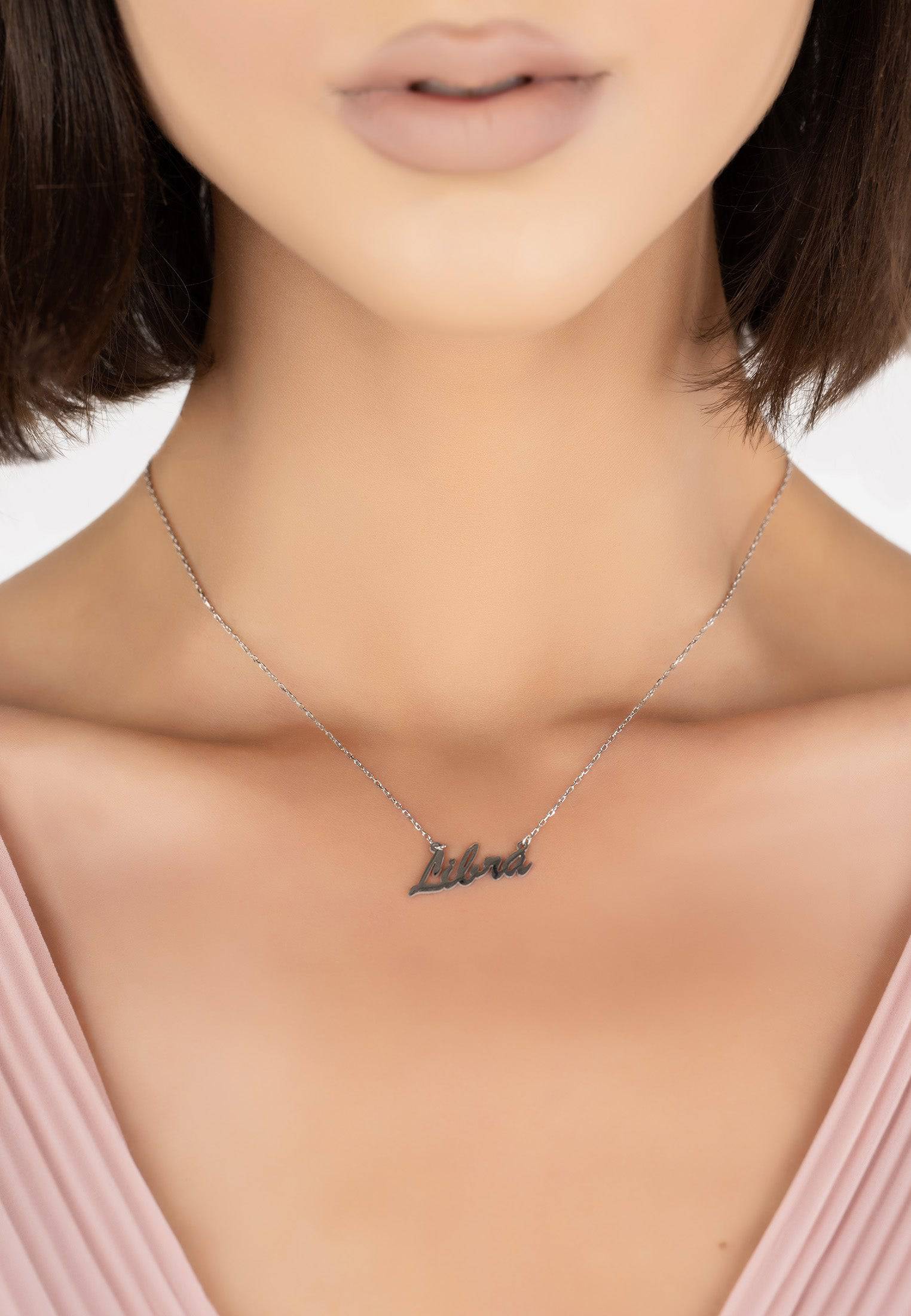 Silver zodiac star sign name necklace featuring the Libra symbol, elegantly designed for stylish layering.