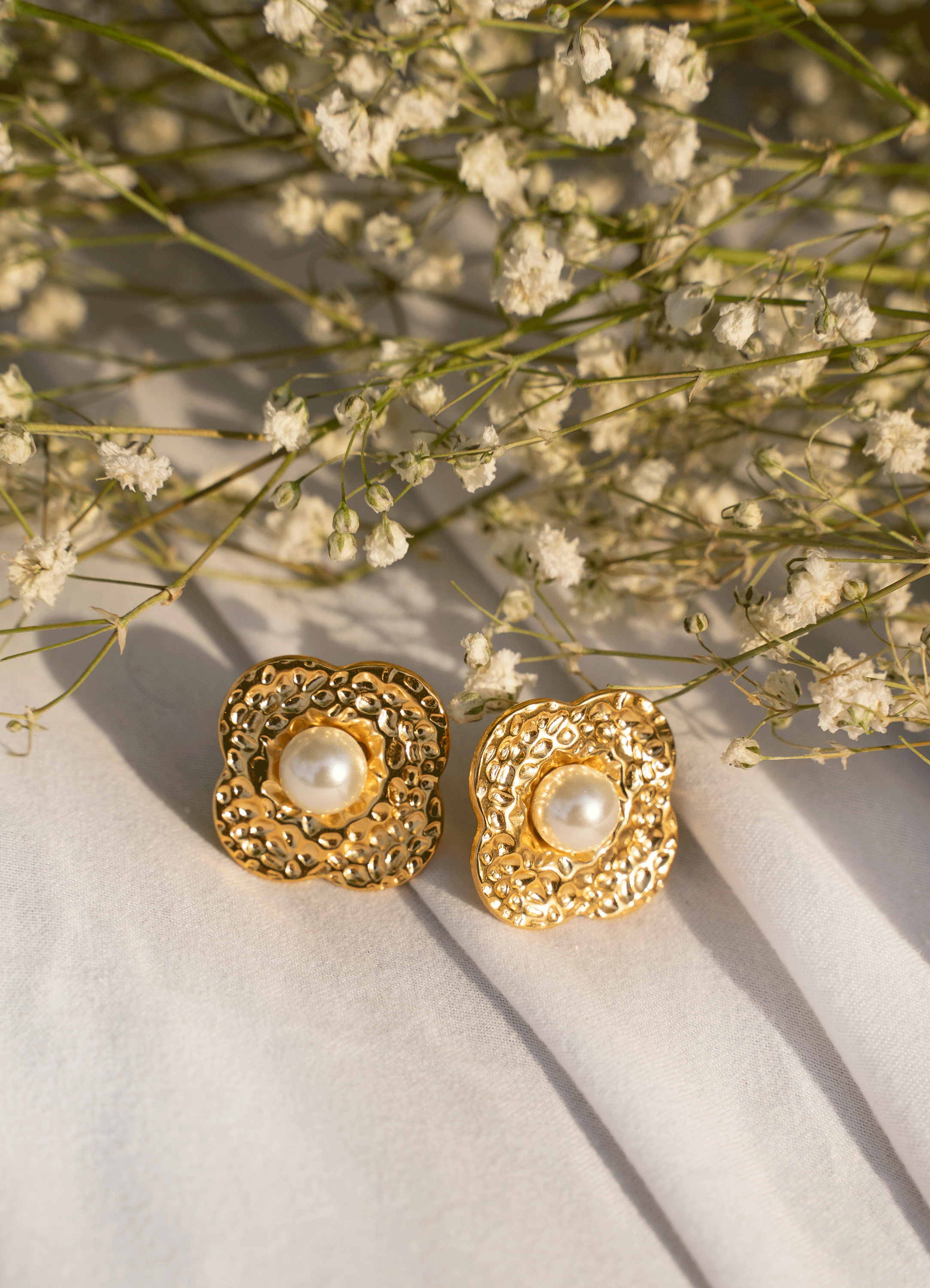 ZYANA Studs featuring hammered flower petals and shimmering pearls, crafted from 18k gold plated stainless steel.