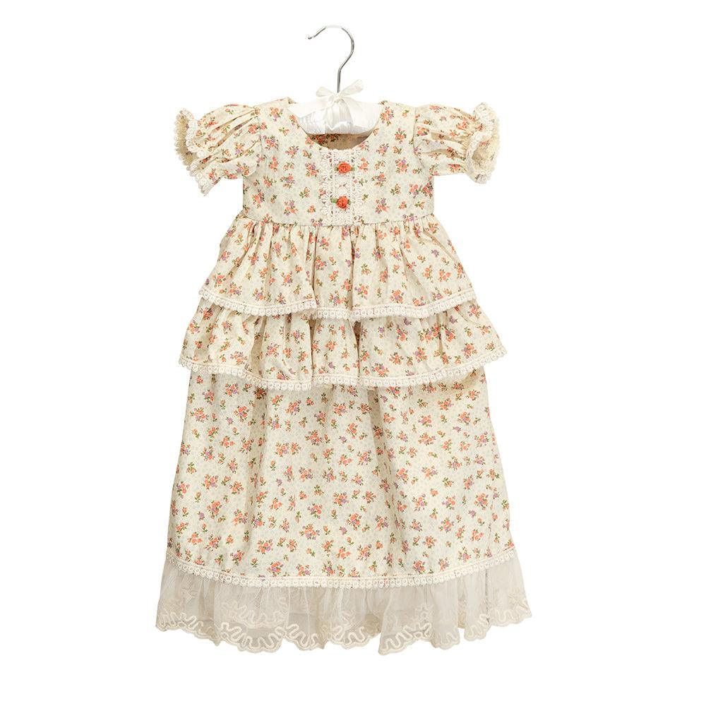 A beautiful floral vintage baby gown with delicate lace trims and puffed sleeves, perfect for special occasions.