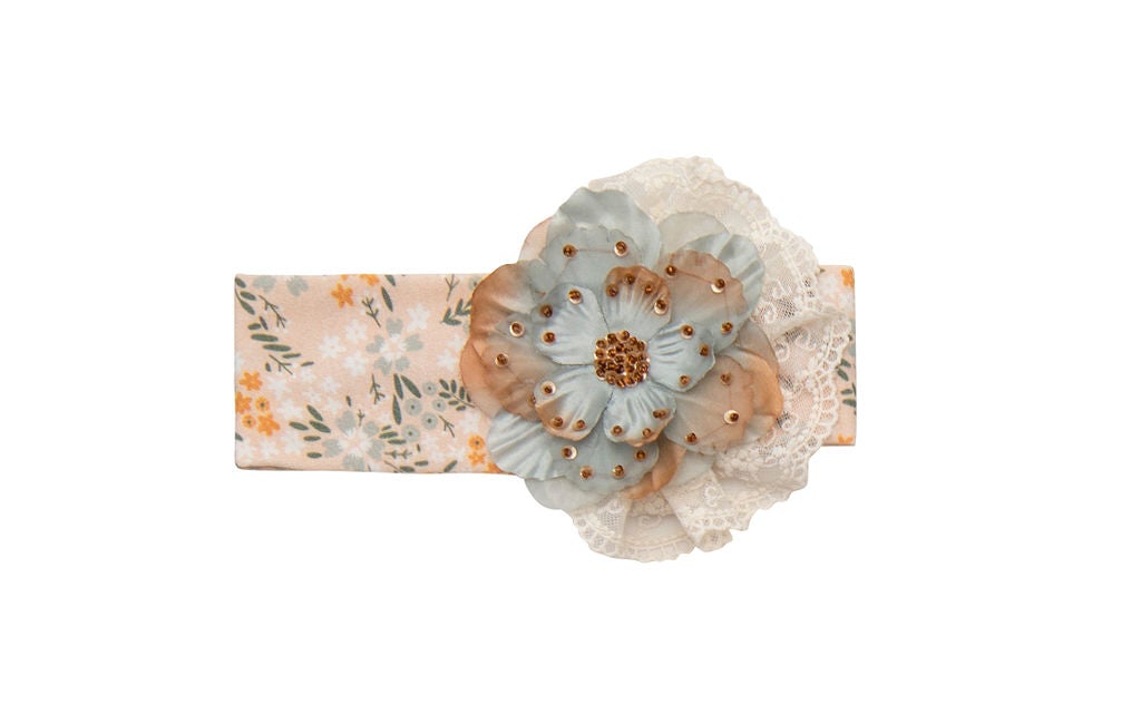 Avas Garden Headband featuring pastel orange colors and delicate lace details, perfect for stylish outfits.