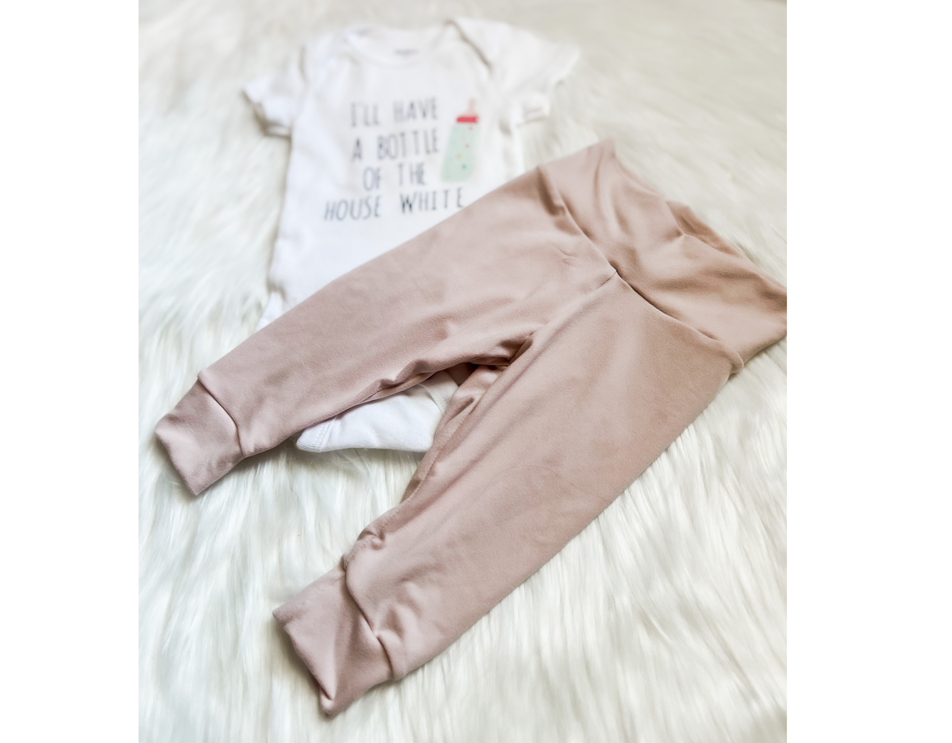 A soft and stylish Bottle of House White Baby Outfit featuring leggings and a bodysuit, perfect for babies.