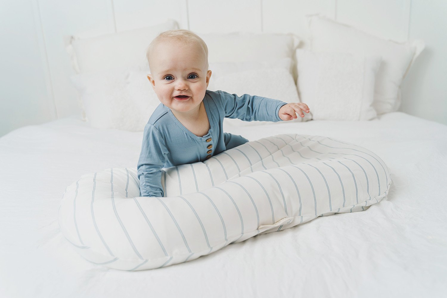 A cozy COCOON & COVER baby lounger in a soft color, featuring a removable liner and a custom-fit traveling case, designed for infants aged 0-36 months.