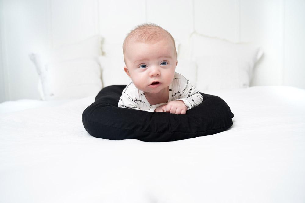 A cozy COCOON & COVER baby lounger in a soft color, featuring a removable liner and a custom-fit traveling case, designed for infants aged 0-36 months.