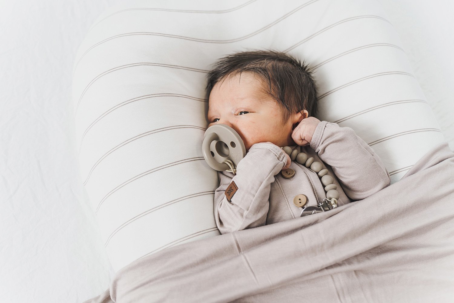 A cozy COCOON & COVER baby lounger in a soft color, featuring a removable liner and a custom-fit traveling case, designed for infants aged 0-36 months.