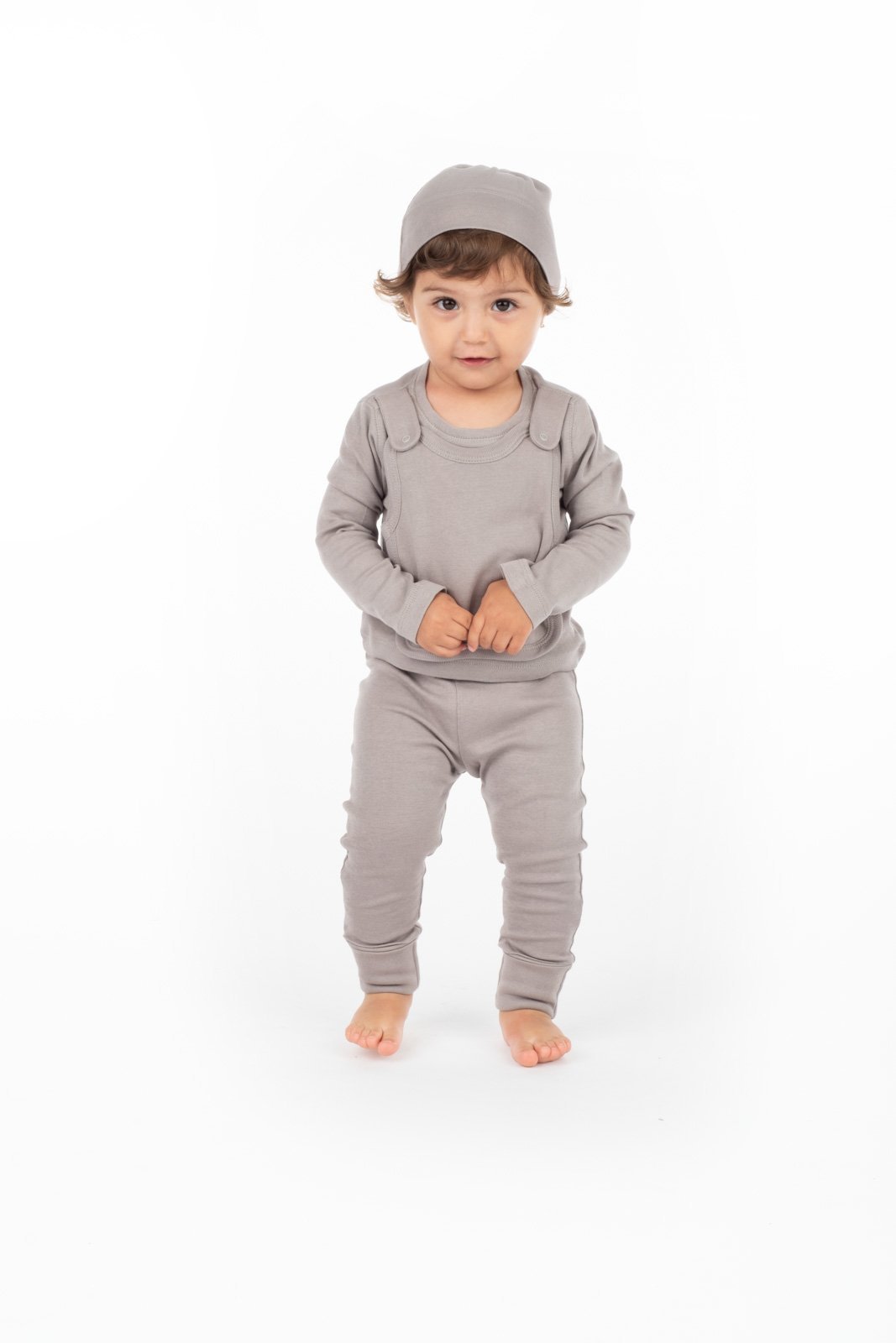 Toddler in gray outfit standing.