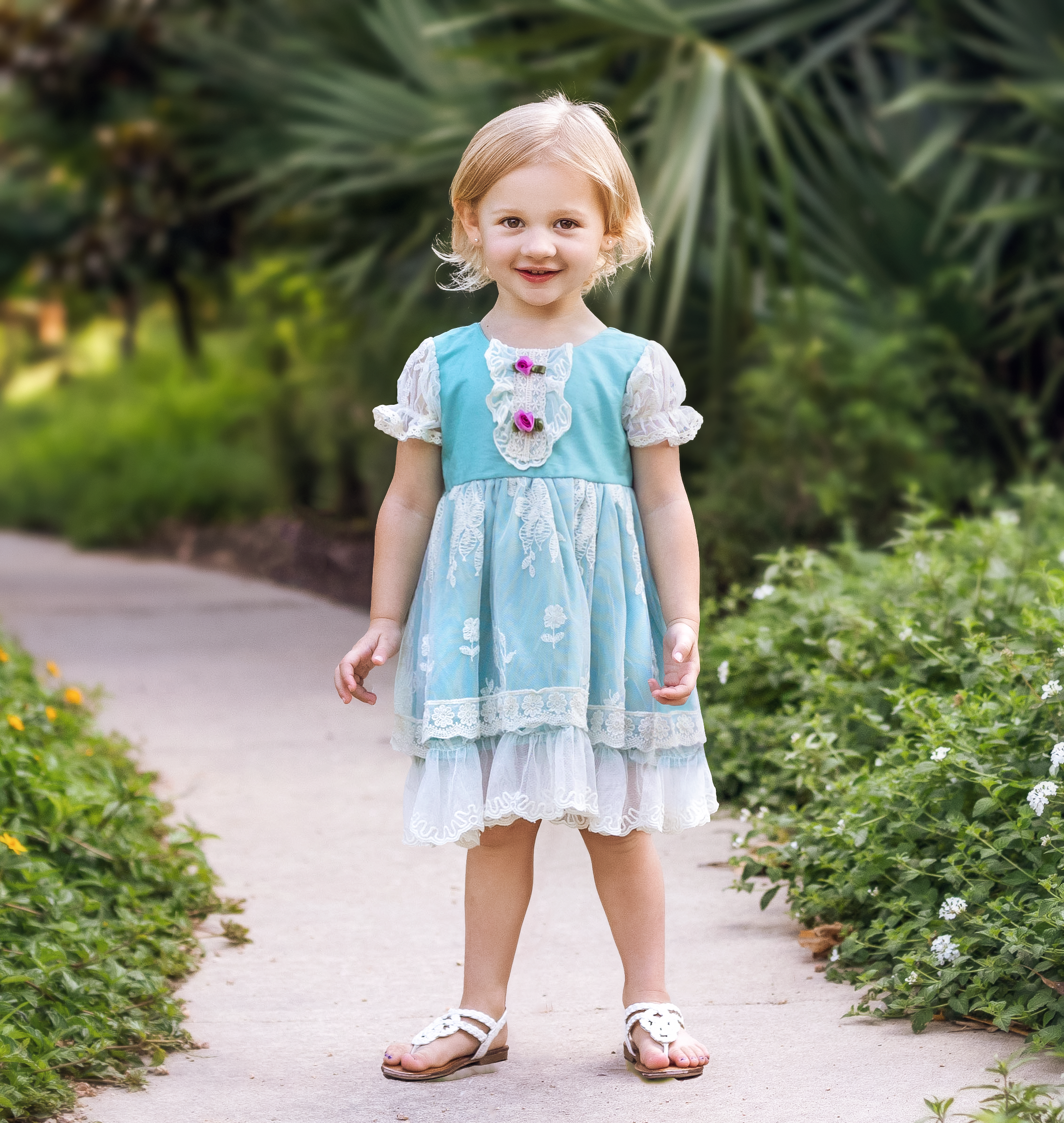 Harper Baby Dress in turquoise featuring ruffles, lace, and rosettes, perfect for infants.