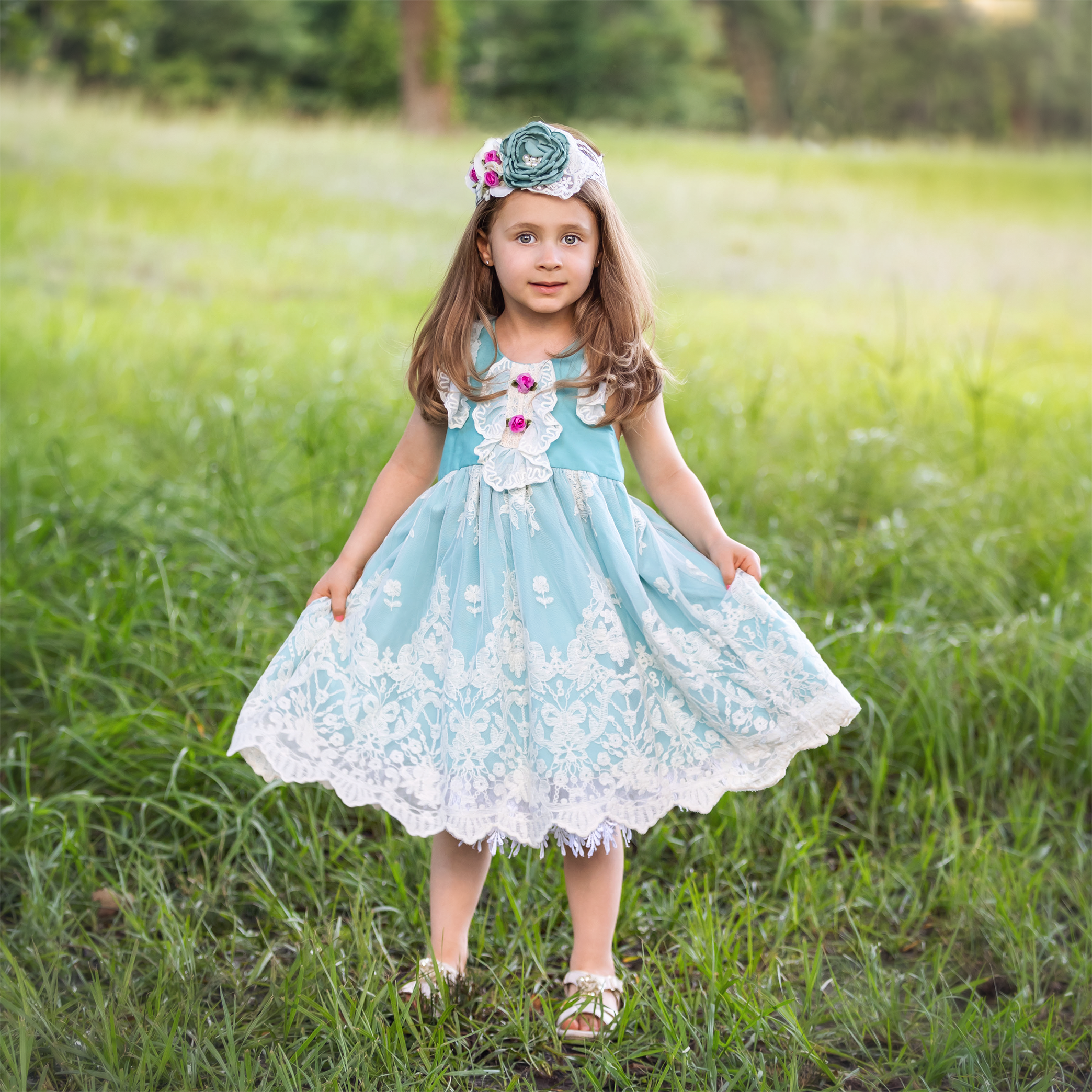 A lovely turquoise Harper Dress featuring ruffles, lace, and rosettes, perfect for little girls.