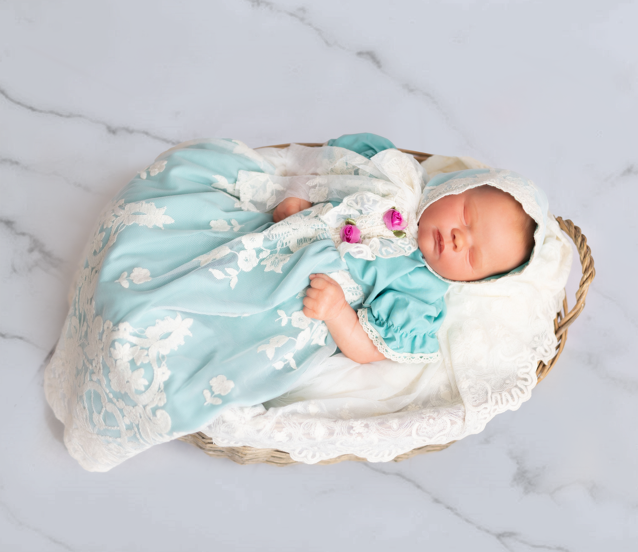 A beautiful turquoise baby gown with ruffles, lace, and rosettes, perfect for special occasions.