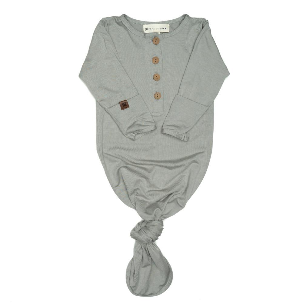 A soft and stylish knotted gown for babies, featuring functional buttons and a cozy design, perfect for diaper changes.