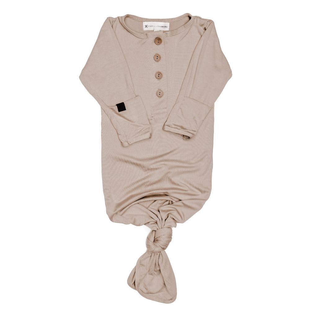 A soft and stylish knotted gown for babies, featuring functional buttons and a cozy design, perfect for diaper changes.