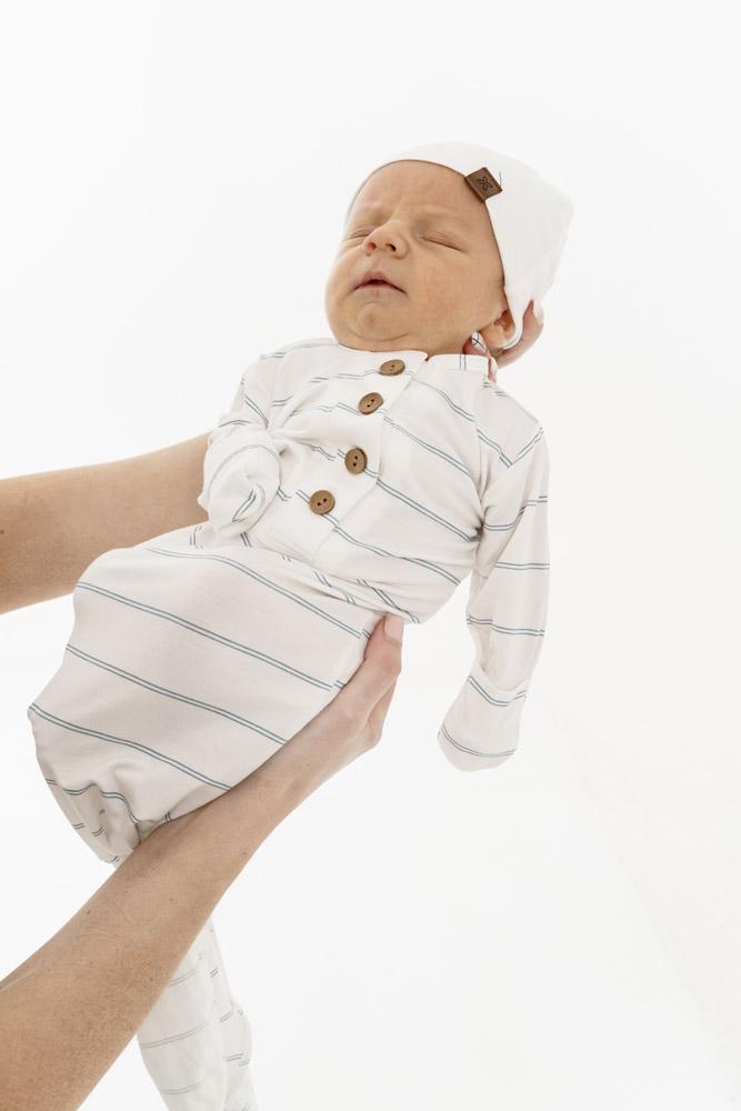 A soft and stylish knotted gown for babies, featuring functional buttons and a cozy design, perfect for diaper changes.