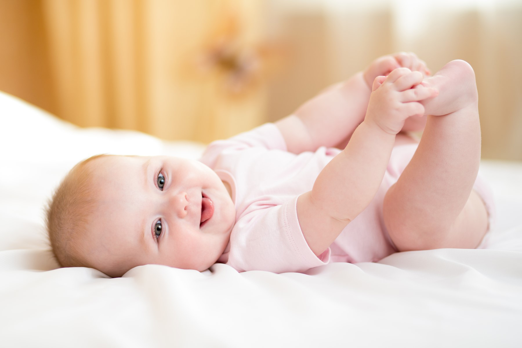 Newborn baby girls' layette set featuring soft cotton clothing, including a pink baby cap, designed for comfort and easy dressing.