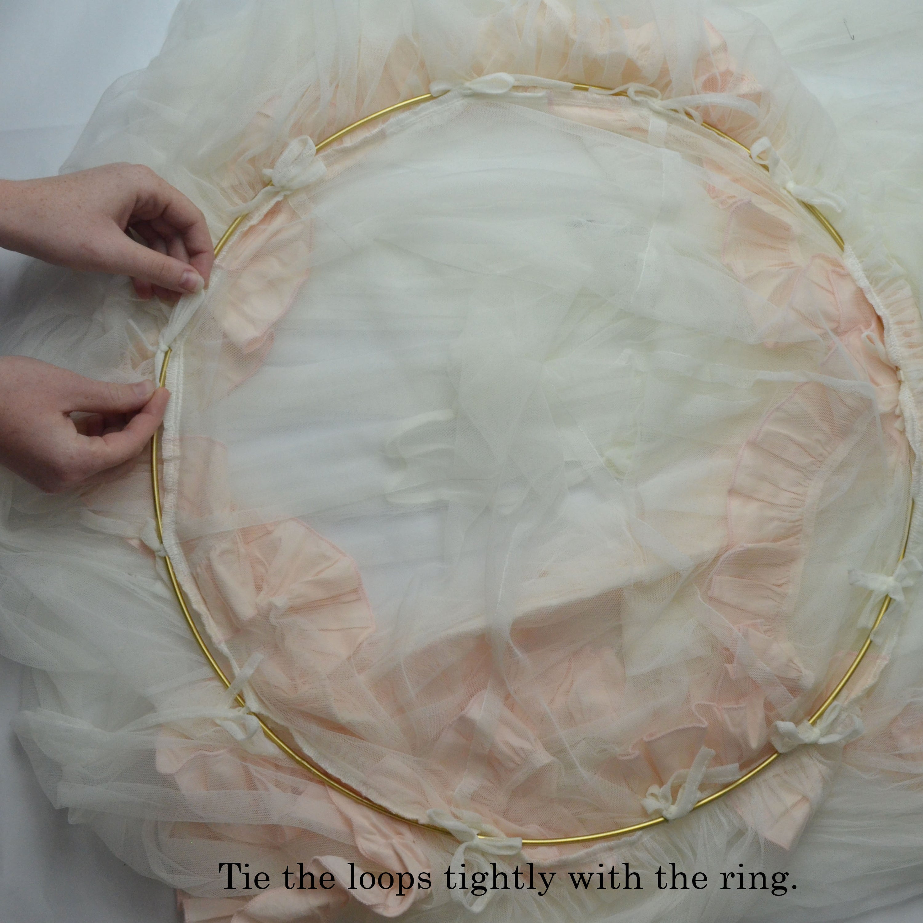 A beautiful blush pink lace tulle canopy draped over a crib, creating a dreamy nursery atmosphere.