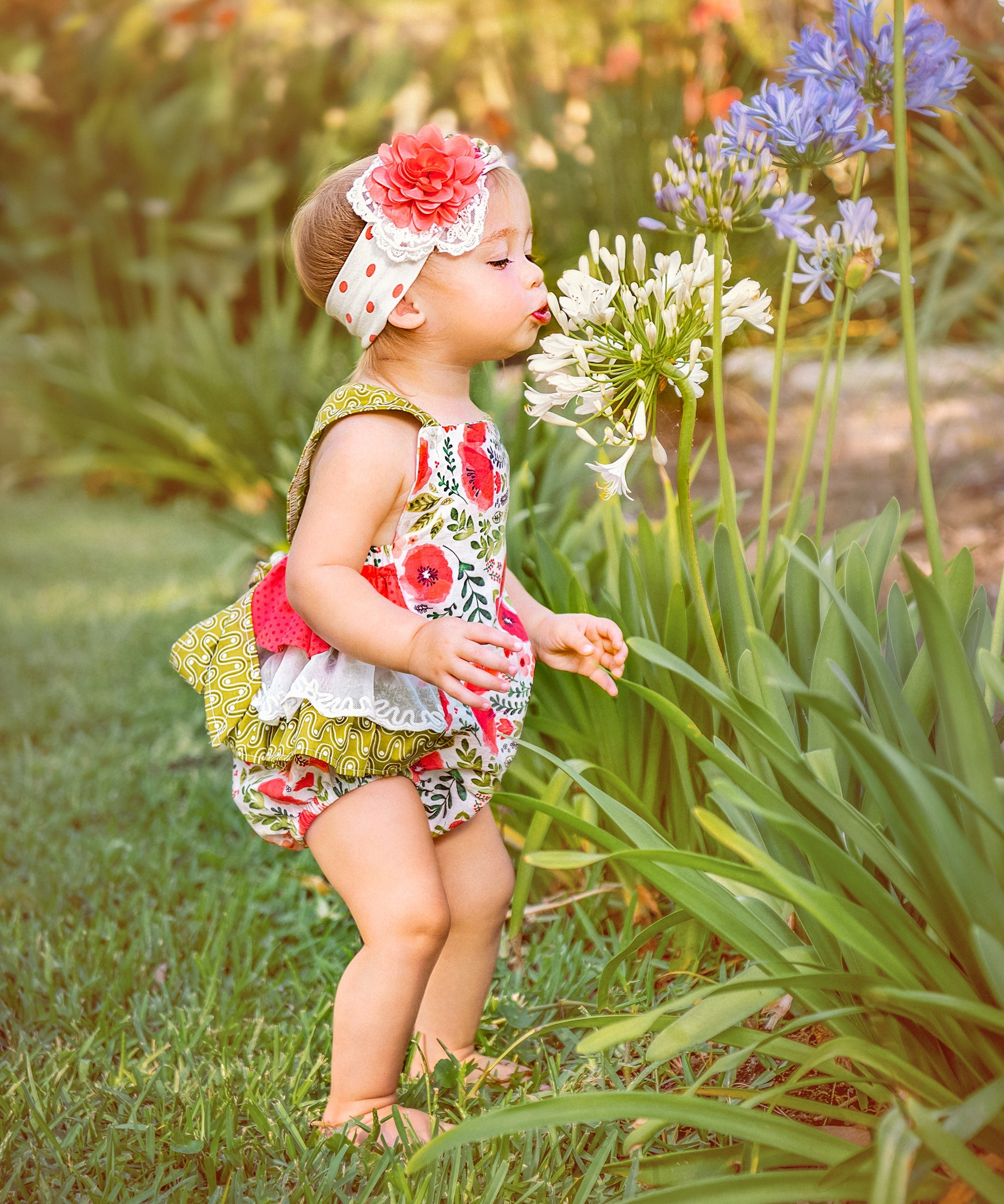 A colorful Poppy Garden Sunsuit featuring a vibrant floral print, designed for children to wear during sunny outdoor activities.