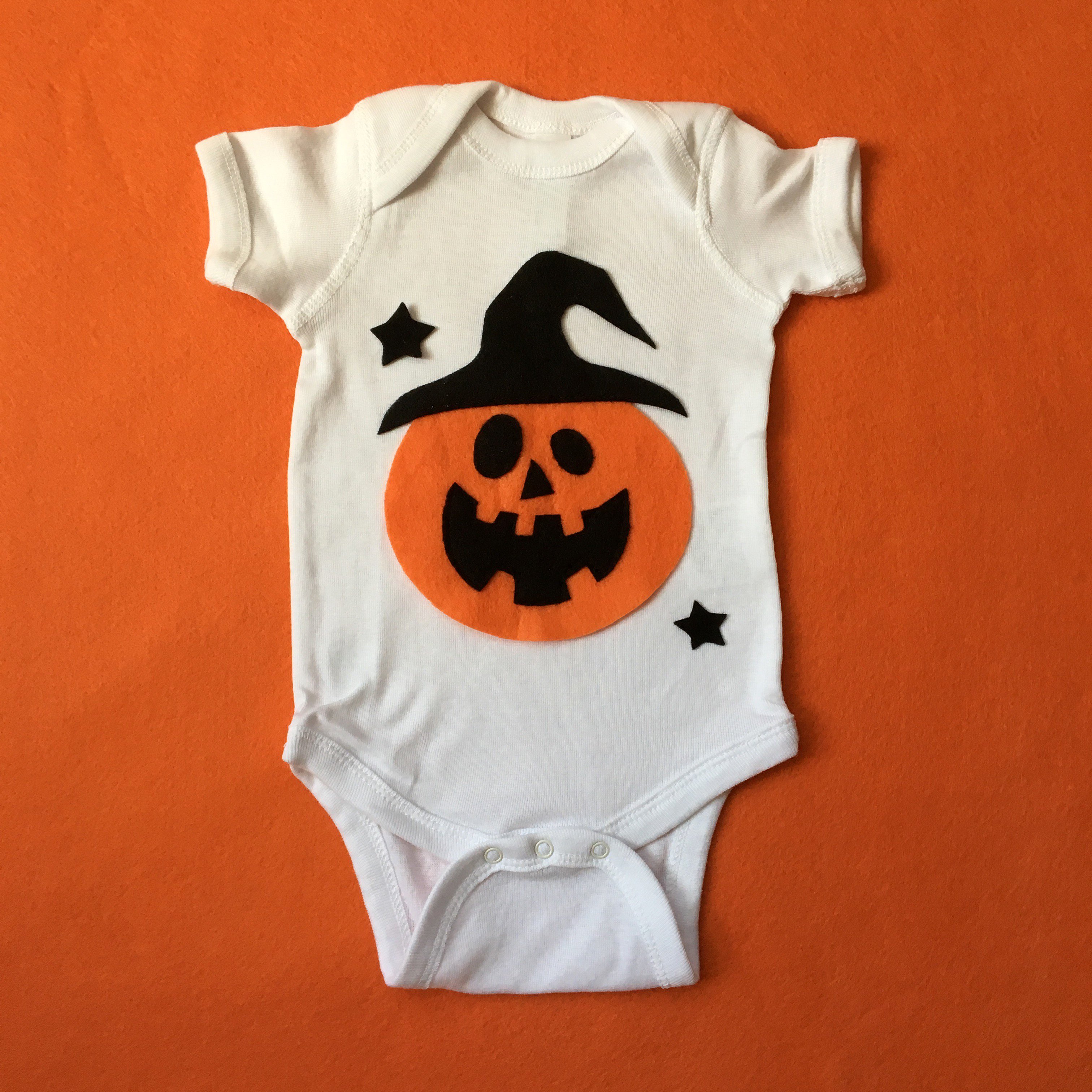 Adorable handmade Pumpkin Witch baby bodysuit with felt appliqué design, perfect for Halloween celebrations.