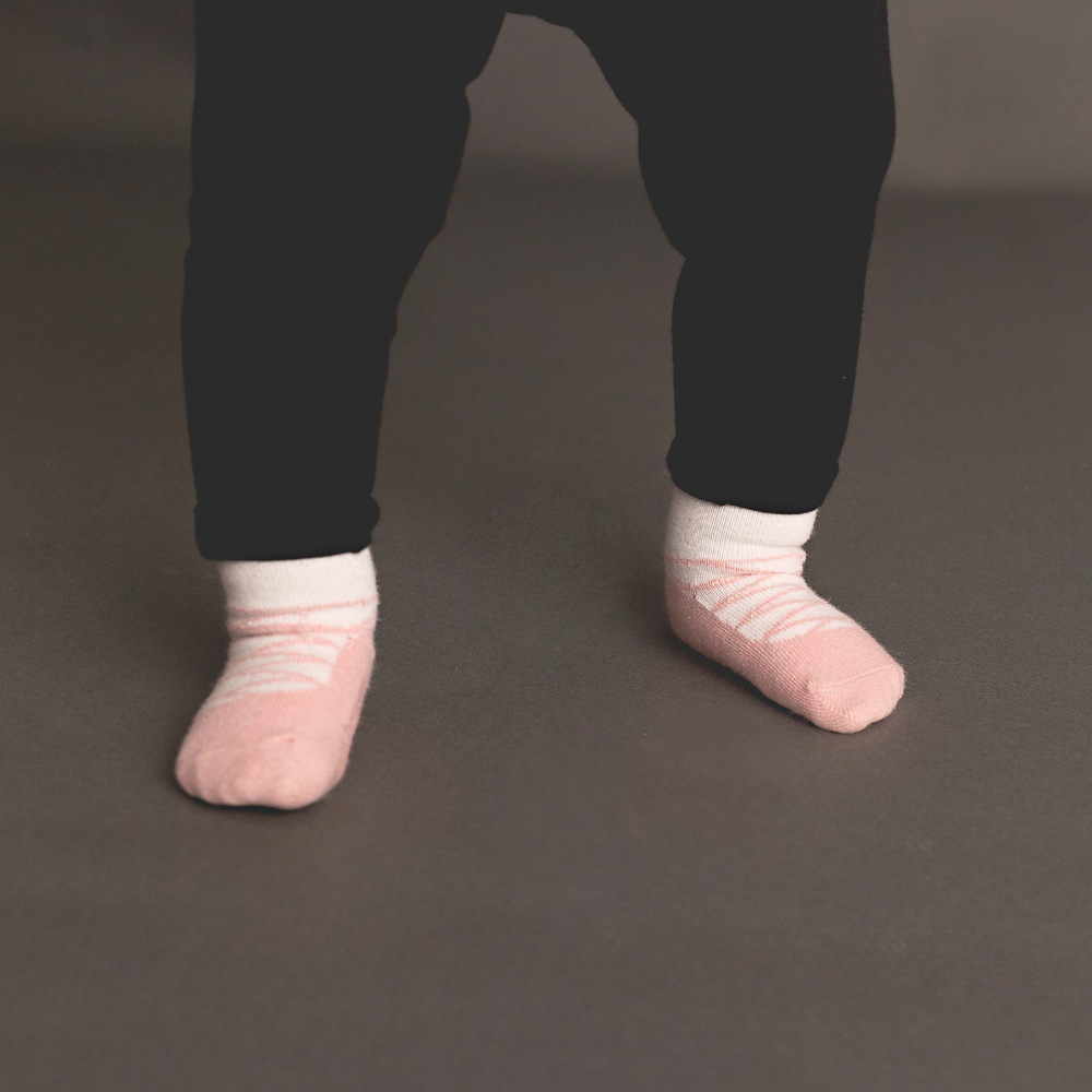 The Bellina Soft Stretch Leggings featuring attached ballet socks in pink and ivory with rubber grippers for traction.