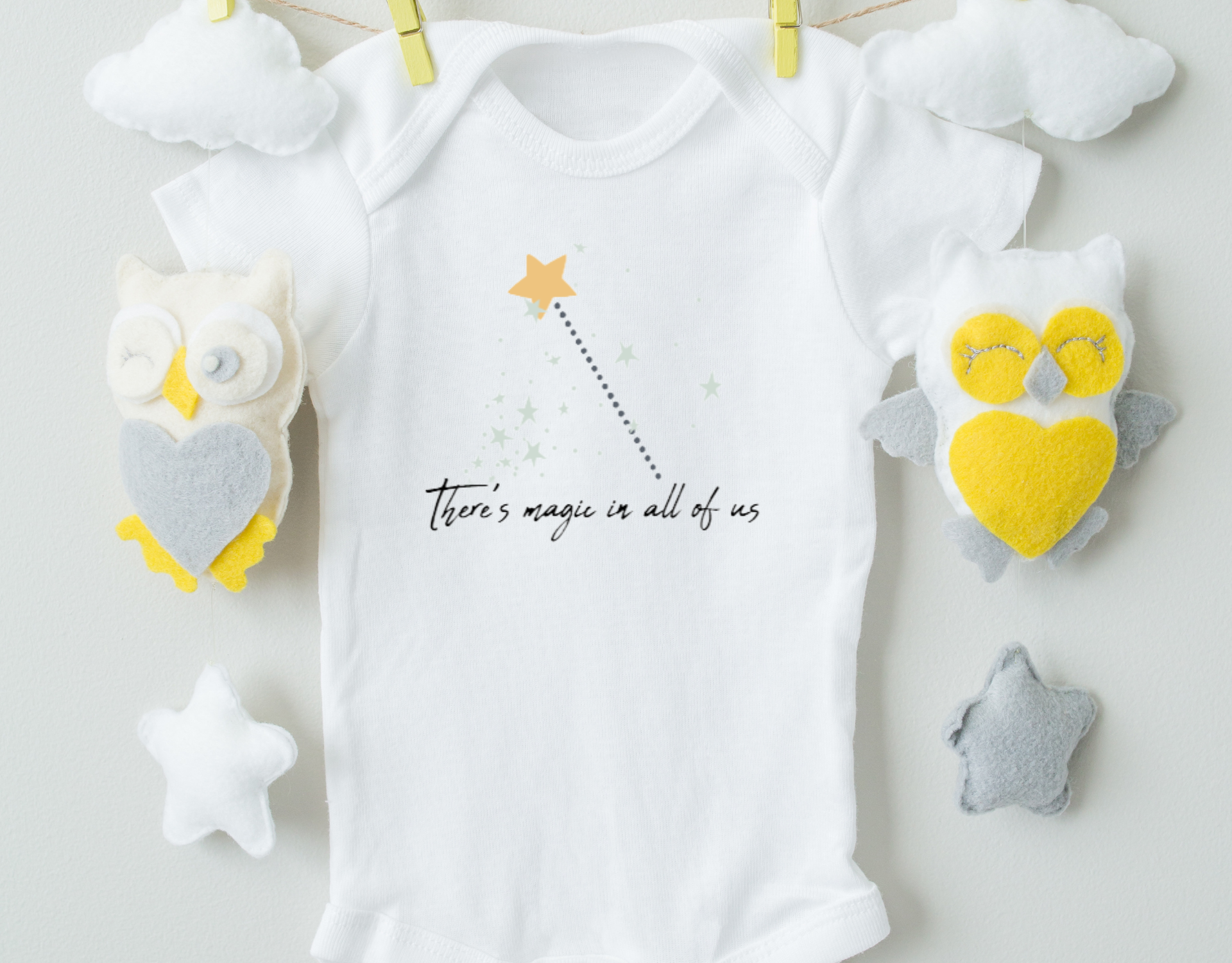 A charming organic cotton bodysuit featuring the phrase 'There's Magic In All Of Us', designed for infants with an expandable neckline and snap closure.